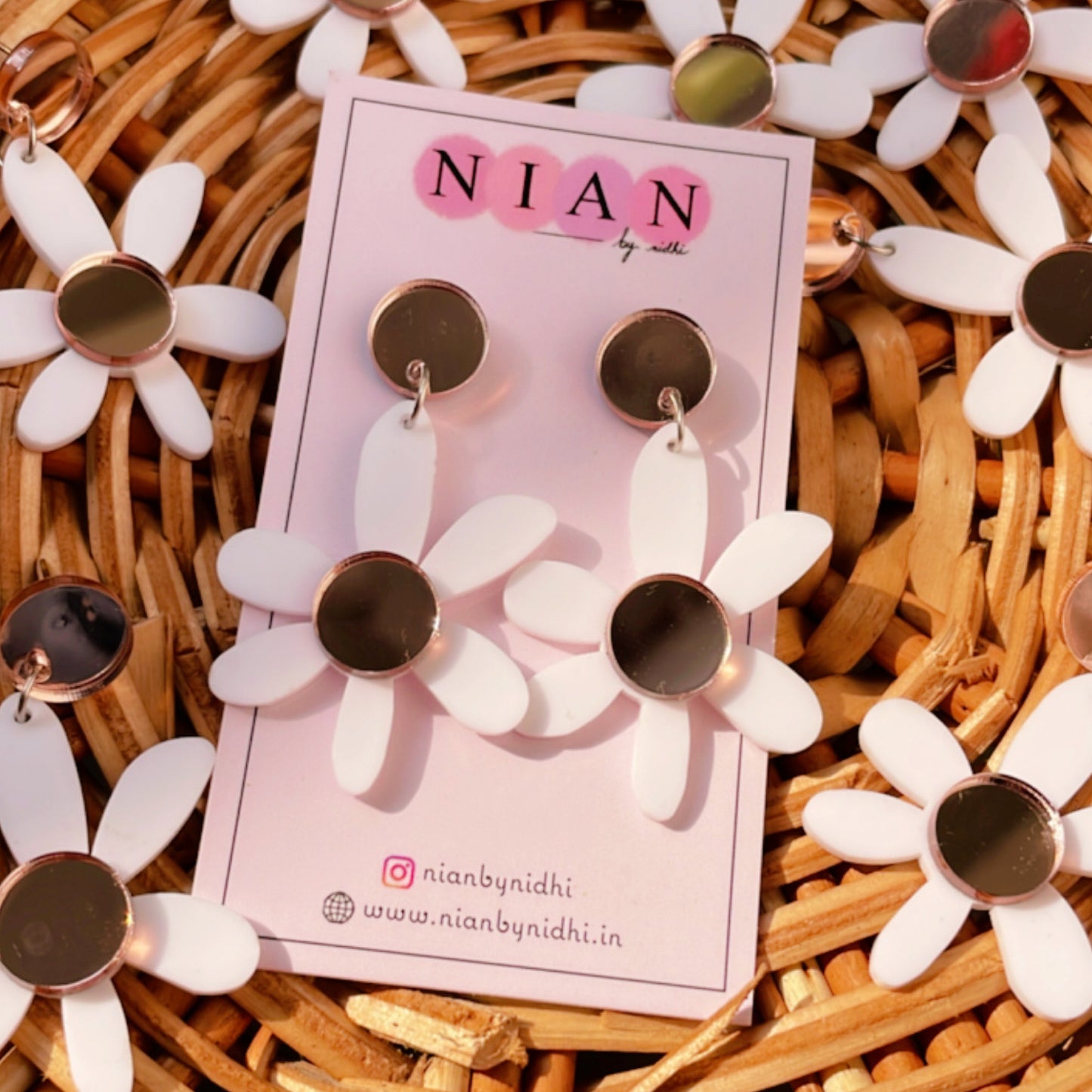 Lush Lily Earrings - White and Rosegold - Nian by Nidhi - placed in a brown basket along with other similar earrings